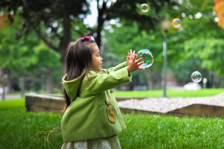 small children catching bubbles